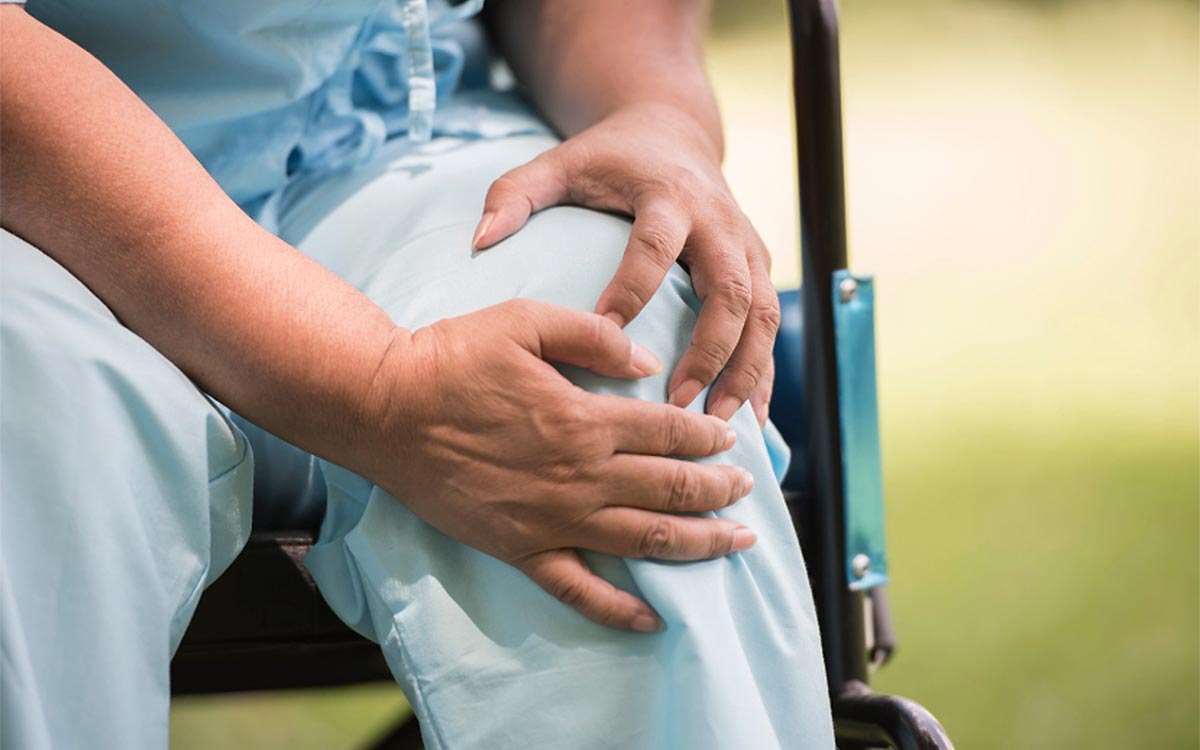 Woman holding her knee wondering if knee surgery hurts.