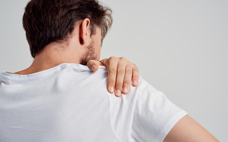 Man holding his shoulder - Rotator Cuff Tear or Impingement: Common Causes of Shoulder Pain